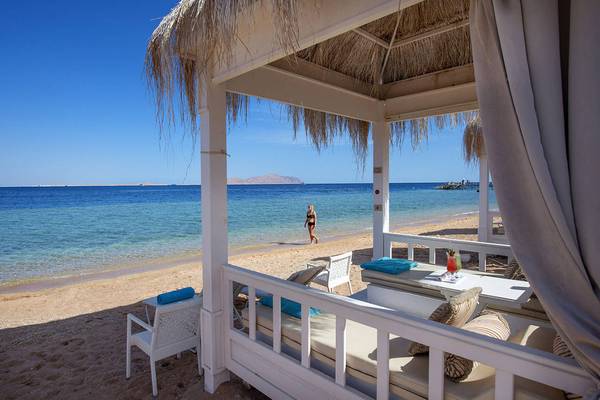 Außenbereich eines Hotels mit Blick auf das Meer und eine Person am Strand.