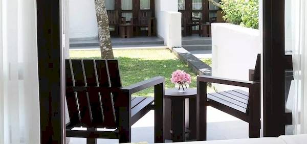 Bett und Sitzecke im Zimmer des Avani Kalutara Resorts mit Blick auf den Garten