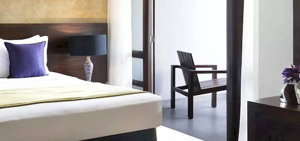Hotelzimmer im Avani Kalutara Resort mit Doppelbett, Kissen, Lampen und Möbeln.