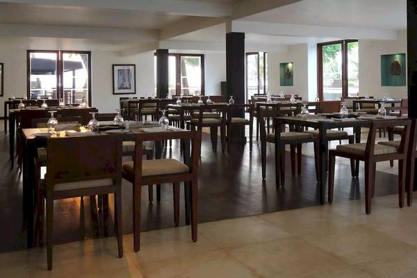 Restaurant im Avani Kalutara Resort mit gedeckten Tischen und Stühlen.