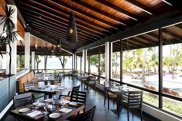 Innenbereich des Restaurants im Avani Kalutara Resort mit Blick auf den Ozean und Palmen