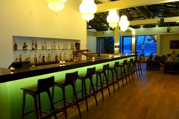 Barszene im Avani Kalutara Resort mit grünen Leuchtleisten und Hockern.