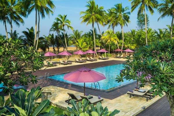 Außenpoolbereich des Avani Kalutara Resorts mit Sonnenschirmen und Liegestühlen.