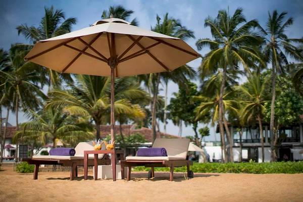 Strand mit Liegen und Sonnenschirm im Avani Kalutara Resort