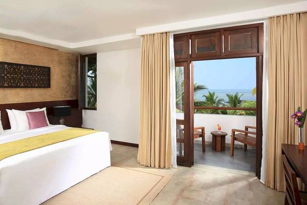 Zimmer im Avani Kalutara Resort mit Balkon und Meerblick, Bett, Kissen und Dekor.