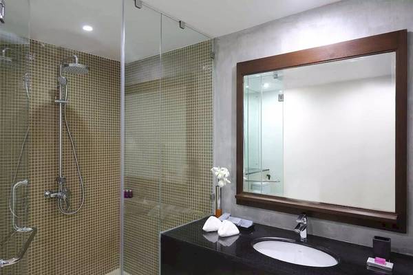 Badezimmer im Avani Kalutara Resort mit Glasdusche, Waschbecken und Spiegel