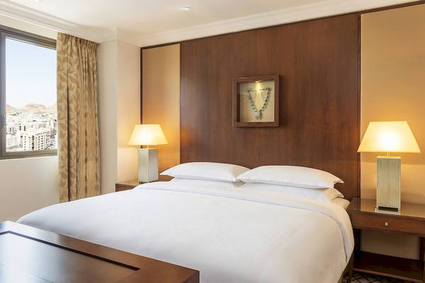 Schlafzimmer im Sheraton Oman Hotel mit Bett, Lampen und Fenster