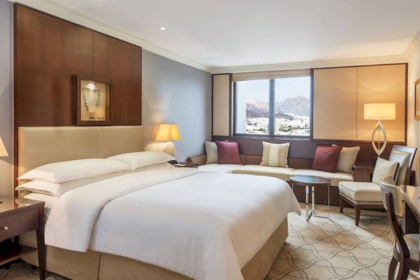 Doppelbett in einem eleganten Hotelzimmer mit Blick auf die Stadt.