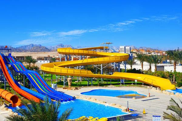 Wasserrutschen im Pickalbatros Royal Moderna Resort mit Swimmingpool im Hintergrund.