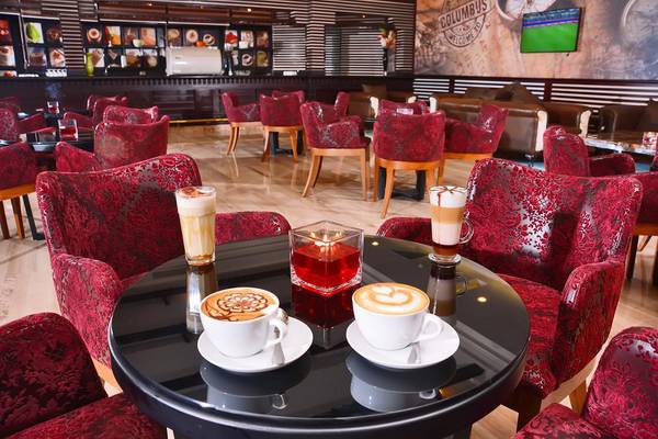 Loungebereich des Pickalbatros Royal Moderna Resort mit rot gepolsterten Stühlen und Kaffeespezialitäten auf dem Tisch.