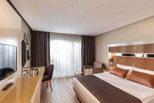 Hotelzimmer von Swandor Hotels & Resorts Topkapi Palace mit Bett, Fernseher, Schreibtisch und Stuhl.