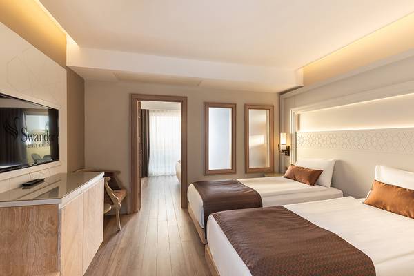 Doppelzimmer im Swandor Hotels & Resorts Topkapi Palace mit zwei Betten, Fernseher, Spiegel und Dekor.
