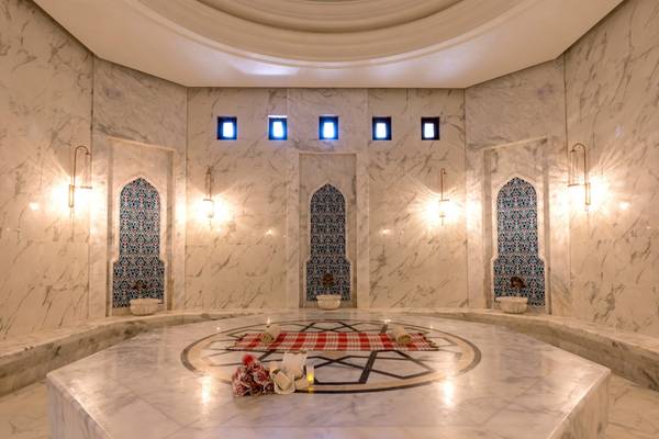 Saunabereich im Swandor Hotels & Resorts Topkapi Palace mit weißen Marmorwänden und zentralen Dekorationen.