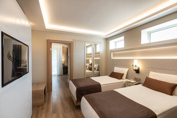 Ein elegantes Doppelzimmer im Swandor Hotels & Resorts Topkapi Palace mit zwei Betten, heller Beleuchtung und modernen Möbeln.