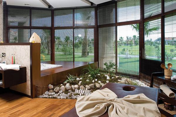 Wellnessbereich im Defne Kumul Deluxe Hotel mit Jacuzzi, Pflanzen und Ausblick auf die Landschaft.