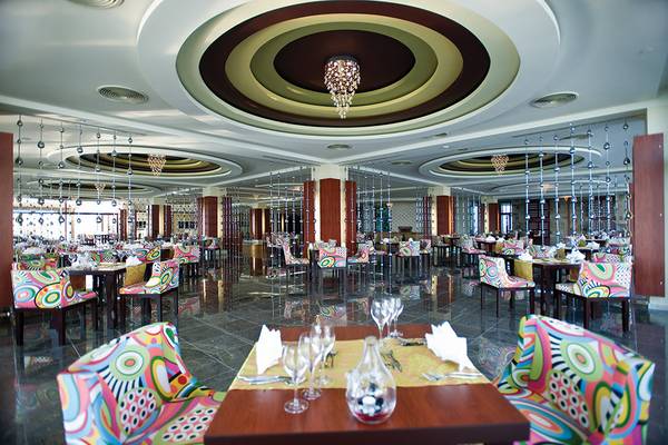 Innenansicht des Restaurants im Defne Kumul Deluxe Hotel mit bunten Stühlen und Tischen.