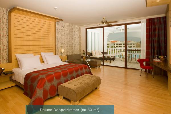 Defne Kumul Deluxe Doppelzimmer mit Balkon, großzügigem Bett und modernen Möbeln.