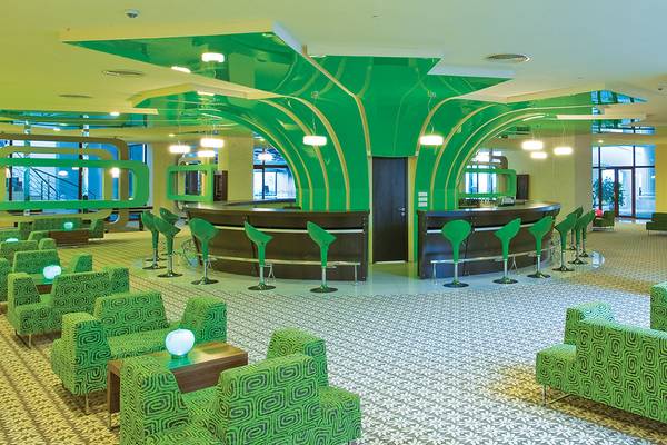 Loungebereich im Defne Kumul Deluxe Hotel mit grünen Möbeln und einer zentralen Bar.