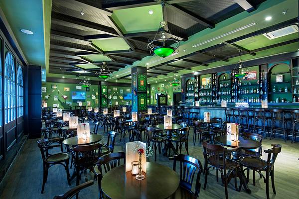 Innenansicht der Bar im Crystal Waterworld Aqua Collection Hotel mit grüner Beleuchtung und Holzmöbeln.