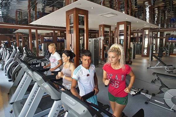 Fitness Center im Crystal Waterworld Aqua Collection Hotel mit Personen auf Laufbändern.