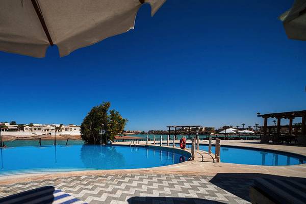 Ein großer Pool im Freien im Sultan Bey Resort mit blauem Wasser und einem Sonnenschirm.
