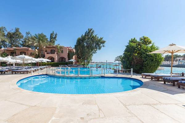 Ein Swimmingpool im Freien mit Liegestühlen und Sonnenschirmen am Sultan Bey Resort.