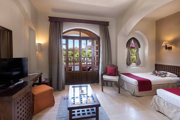 Zimmer im Sultan Bey Resort mit Fernseher, Bett, Tisch und Balkontür