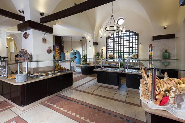 Innenansicht des Speisesaals im Sultan Bey Resort mit Buffets, Tischdekoration und einer Glasdecke.