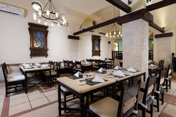 Innenansicht des Restaurants im Sultan Bey Resort mit gedeckten Tischen und dekorativen Wandelementen.