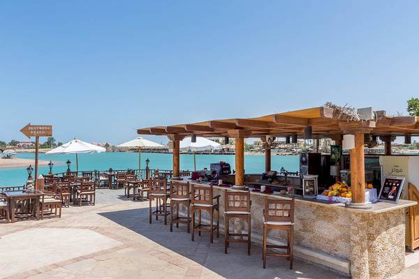 Terrasse des Sultan Bey Resorts mit Bar, Tischen und Stühlen am Meer
