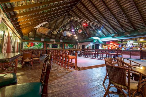 Innenansicht der Bar im Marien Puerto Plata Hotel mit Holzboden, Möbeln und einer Theke.