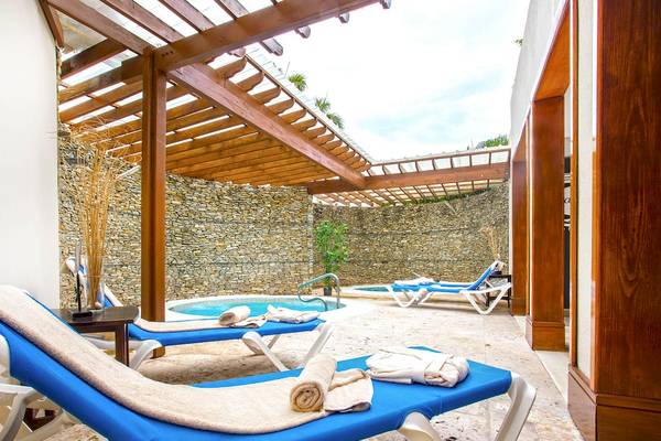 Loungebereich im Marien Puerto Plata Hotel mit Außenpool und Liegestühlen.