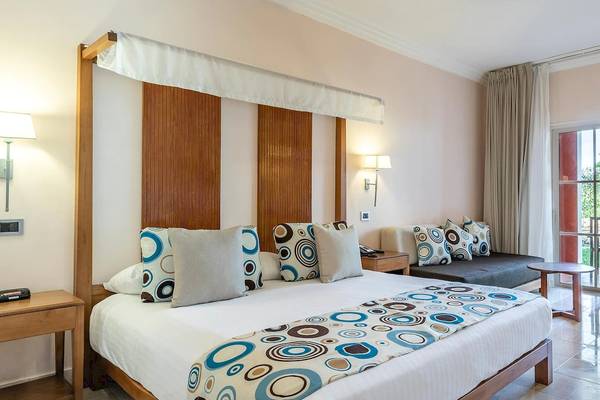 Schlafzimmer im Marien Puerto Plata Hotel mit großem Bett, dekorativen Kissen und moderner Einrichtung.