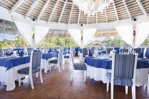 Innenansicht des Restaurants im Hotel Marien Puerto Plata mit blauen und weißen Tischdecken und Stühlen.