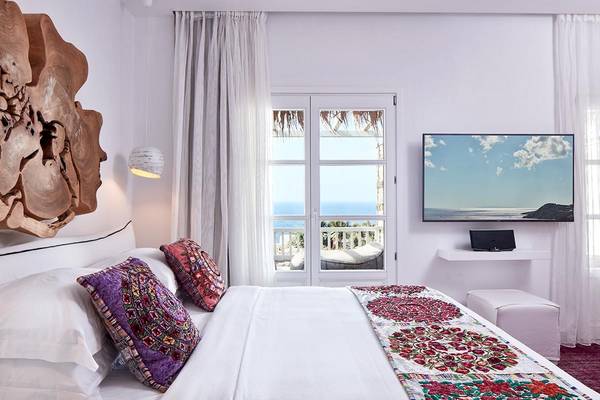 Zimmer der Myconian Villa Collection mit einem großen Bett und einem Balkon mit Meerblick.