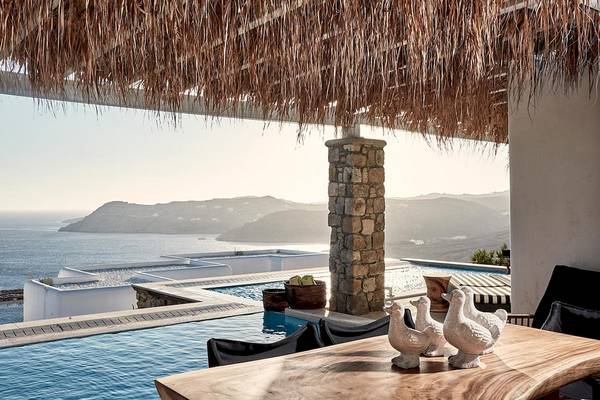 Aussicht auf den Pool der Myconian Villa Collection mit Meer und Bergen im Hintergrund.