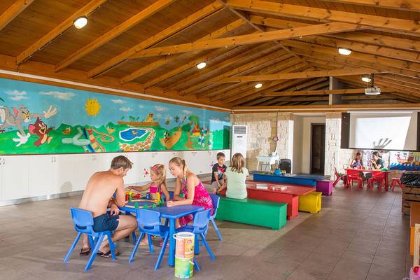 Familienbereich im Gouves Water Park Holiday Resort mit bunten Tischen und Stühlen.