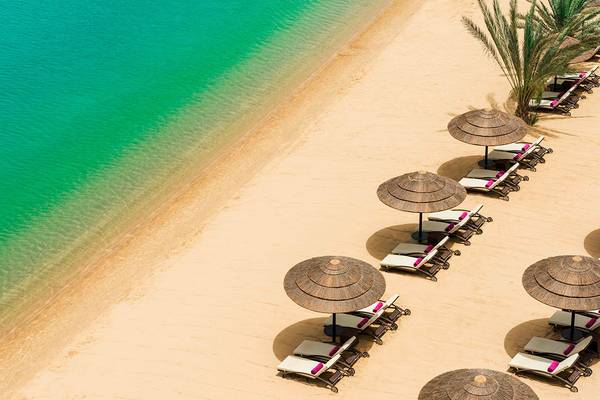 Le Meridien Abu Dhabi Strand mit Lounge-Liegestühlen und Sonnenschirmen