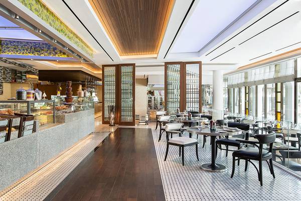 Innenansicht des Restaurants im Le Meridien Abu Dhabi mit Tischen, Stühlen und einer Theke.