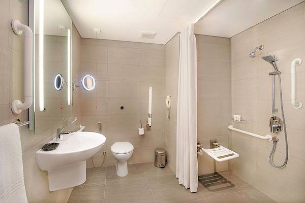 Barrierefreies Badezimmer im Le Meridien Abu Dhabi mit Dusche, Toilette und Waschbecken.