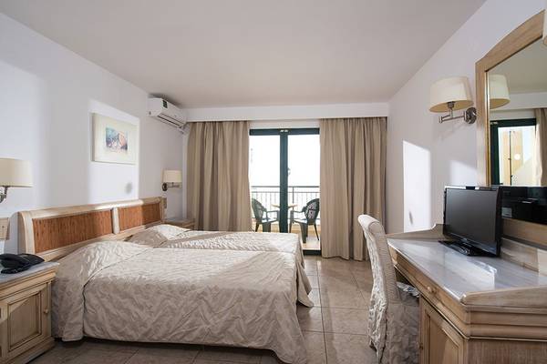 Doppelzimmer mit Balkon im Gouves Water Park Holiday Resort, inklusive zwei Betten und einem Schreibtisch.