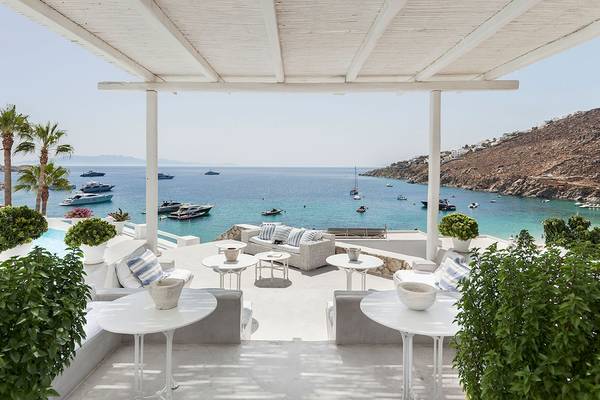 Terrasse im Grecotel Mykonos Blu mit Blick auf das Meer und Yachten.