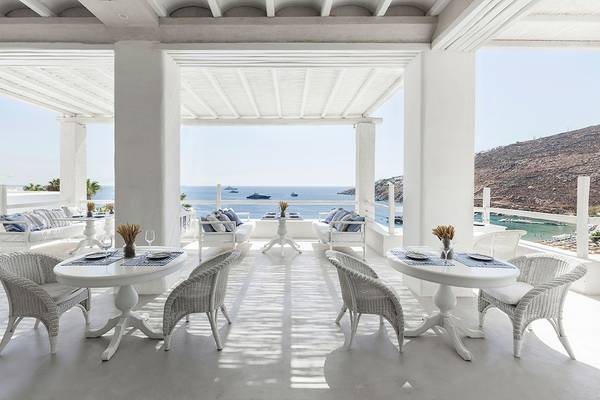 Terrasse des Grecotel Mykonos Blu Hotels mit Blick auf das Meer und Inseln