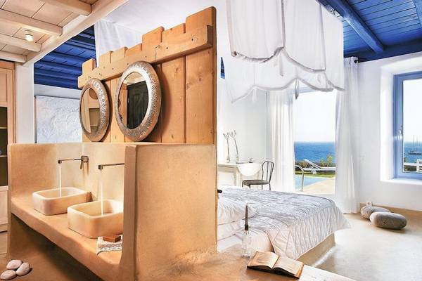 Innenansicht eines Zimmers im Grecotel Mykonos Blu Hotel mit Blick auf das Meer.