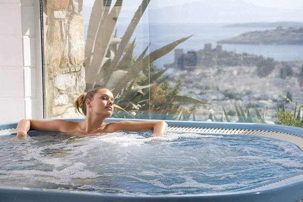 Frau genießt Whirlpool mit Meerblick im Marmara Bodrum Hotel