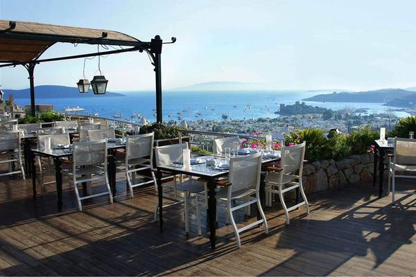 Außenterrasse des Marmara Bodrum Hotels mit Blick auf das Meer und die Stadt.