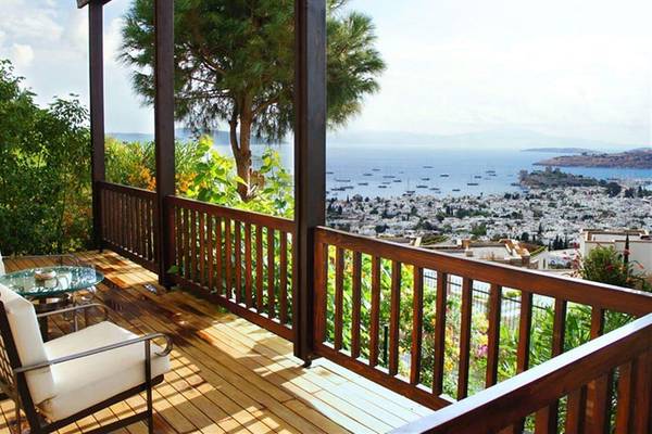 Terrasse mit Meerblick im Marmara Bodrum Hotel mit zwei weißen Stühlen und einem Glastisch.