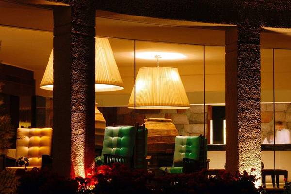 Lobby des Marmara Bodrum Hotels mit illuminierten Leuchten und grünen Stühlen.
