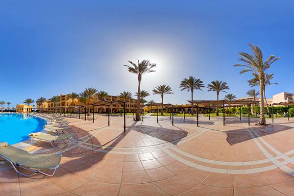 Panorama des Pools im Jaz Samaya Resort mit Liegestühlen und Palmen