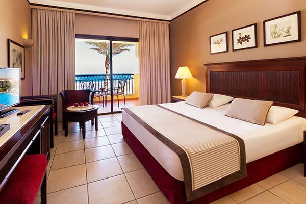 Hotelzimmer mit Meerblick im Jaz Samaya Resort, inklusive Bett, Fernseher, Schreibtisch und Balkon.
